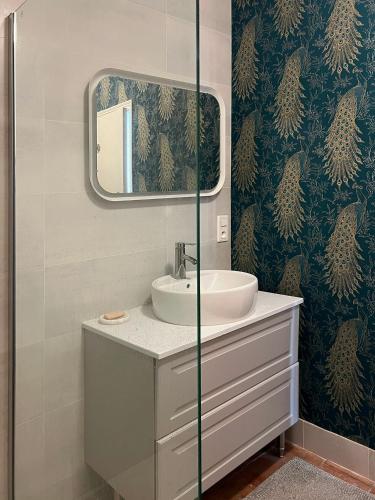 une salle de bain avec un lavabo et un miroir dans l'établissement Moulin des Arts, à Loché-sur-Indrois