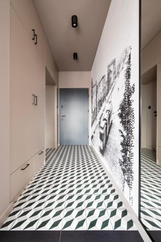 a hallway with black and white tile floors and a door at Apartamenty Rocha in Pabianice
