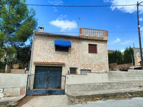 a house with a blue window and stairs at Brisas del Lago in Navarrés