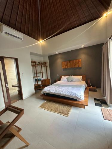 a bedroom with a large bed in a room at Happy Nest Canggu in Tumbak Bayuh