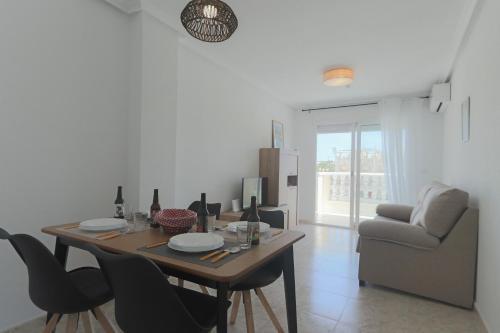 a dining table and chairs in a living room at 099 - Parque y playa 007 - comfortHOLIDAYS in Santa Pola