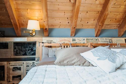 una camera da letto con un letto con soffitto in legno di Appartement - Atelier Ayurvédique - Aline et Oliver a Orschwiller