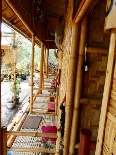 an inside view of a bamboo house with colourful pillows at Uncle Hippie's Dream in Gili Meno