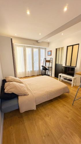 une chambre avec un grand lit dans une pièce avec parquet dans l'établissement Petit Malo, à La Rochelle