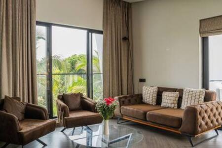 a living room with couches and a glass table at Peacock View 4 BHK Pvt Pool & Jacuzzi at Saligao in Saligao