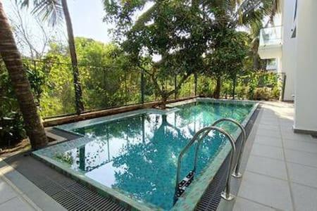 a swimming pool with blue water in a house at Peacock View 4 BHK Pvt Pool & Jacuzzi at Saligao in Saligao