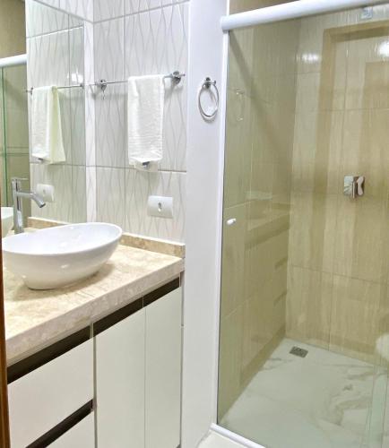 a bathroom with a sink and a glass shower at Family Residences Brás in São Paulo