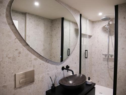 a bathroom with a sink and a round mirror at CANAL APARTMENT AMSTERDAM CENTRAL 4p in Amsterdam