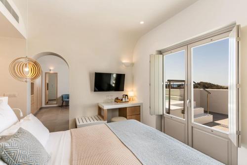 a bedroom with a bed and a desk and a window at Meltemi Blu - Adults Only in Perissa