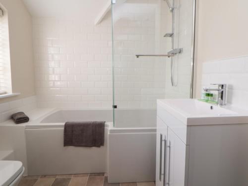 ein weißes Badezimmer mit Badewanne und Waschbecken in der Unterkunft Canal Basin Cottage in Nantwich