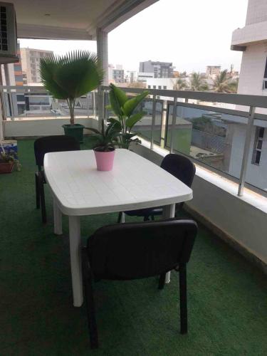 a white table and chairs on a balcony at Vue ocean Almadies 300m2 3CH avec SDB Clim WiFi in Dakar