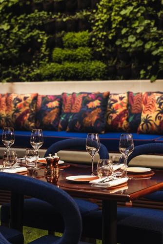 a table with wine glasses and a couch in the background at Maison Barrière Vendôme in Paris