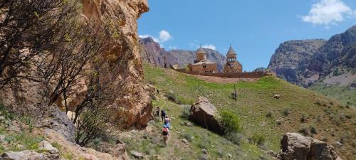 a group of people walking up a hill next to a castle at Sareni in Areni