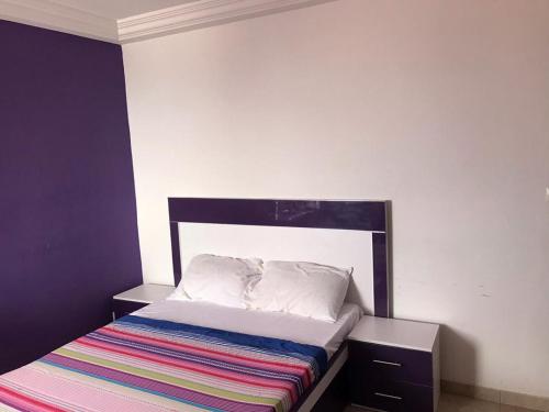 a bedroom with a bed with a striped blanket on it at Vue ocean Almadies 300m2 3CH avec SDB Clim WiFi in Dakar