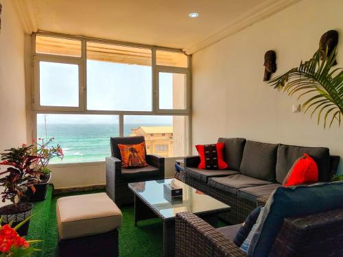 a living room with a couch and a view of the ocean at Vue ocean Almadies 300m2 3CH avec SDB Clim WiFi in Dakar