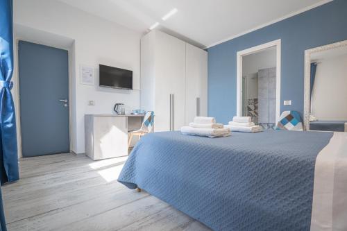 a blue bedroom with a bed with towels on it at La Vedetta in Luras