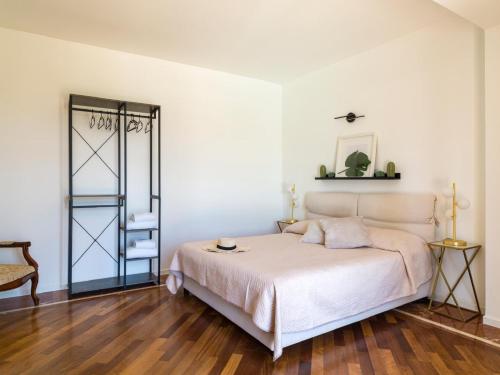 a white bedroom with a bed and a wooden floor at Villa Nunziatina in Carlentini