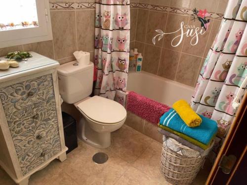 a bathroom with a toilet and a shower curtain at Casa Susi in Tazacorte