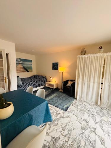 un salon avec une table et une chambre dans l'établissement EMNICE Studio musiciens, à Nice