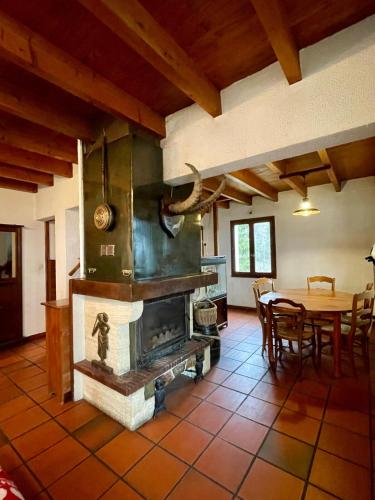 - un salon avec une cheminée et une table à manger dans l'établissement Maison d'exception avec étang privé en chartreuse, à Saint-Pancrasse