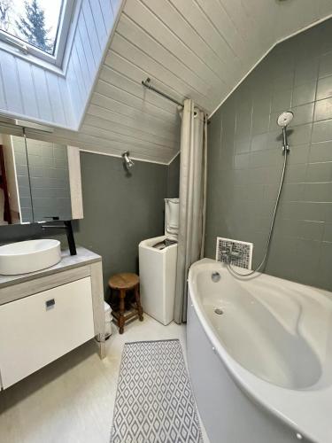 une salle de bain avec une baignoire blanche et un lavabo dans l'établissement Maison d'exception avec étang privé en chartreuse, à Saint-Pancrasse