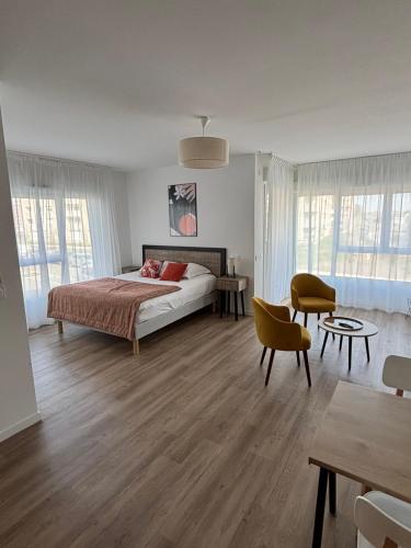 a bedroom with a bed and a table at Résidence Services Seniors DOMITYS - Villa Ulma in Lille