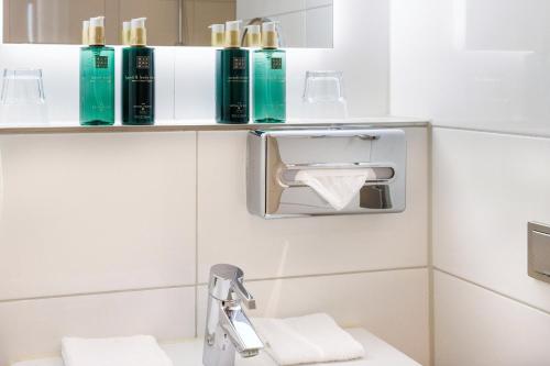 een badkamer met een handdoekendispenser en een wastafel bij Hotel Die Port van Cleve in Amsterdam