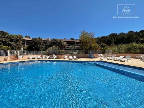 une grande piscine bleue avec des chaises longues dans l'établissement Hortensia Régence Park Swimming pool Beach 300 m away, au Pradet