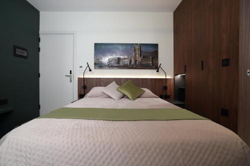 a bedroom with a large bed with a painting on the wall at Bonaci Boutique Hotel in Sliema