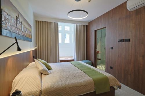 a bedroom with a bed and a large window at Bonaci Boutique Hotel in Sliema