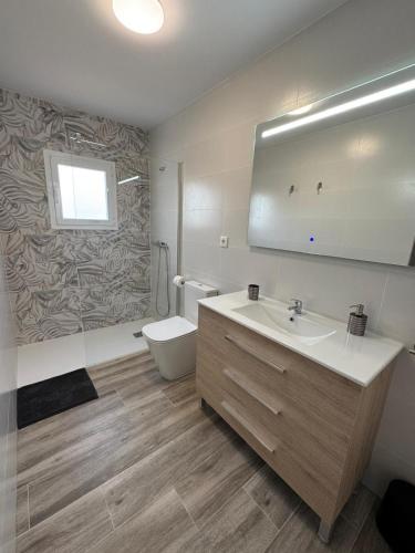a bathroom with a sink and a toilet and a mirror at Bungalow Noa in Calpe