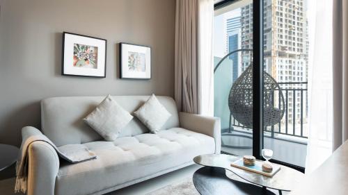 a living room with a couch and a large window at Keyrock - Zada Tower, Business Bay Lake-View Apartment in Dubai