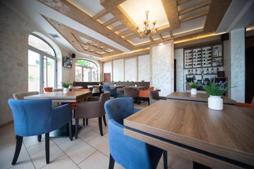 a restaurant with wooden tables and blue chairs at Royal Crown Apartments in Subotica