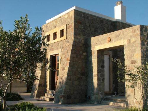 a brick building with a white chimney on top at Villa Patmos Netia in Patmos