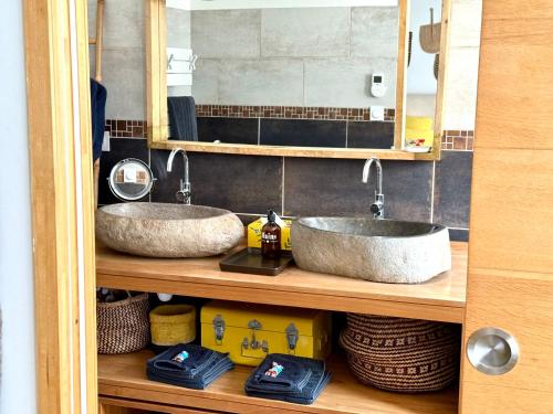 two sinks on a wooden shelf in a bathroom at Origines in Tautavel