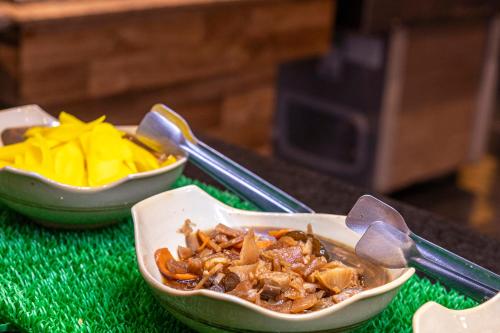 a bowl of food sitting on a table with tongs at Nikkey Palace Hotel in Sao Paulo