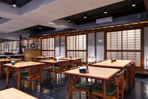 a restaurant with wooden tables and chairs and windows at Nikkey Palace Hotel in Sao Paulo