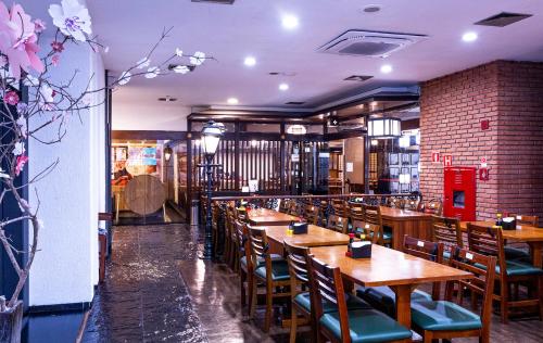 a dining room with wooden tables and chairs at Nikkey Palace Hotel in Sao Paulo
