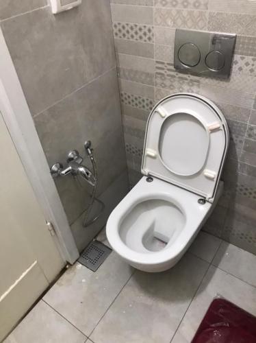a bathroom with a toilet with the lid up at Villa Nesma in Ḩammām al Ghazzāz