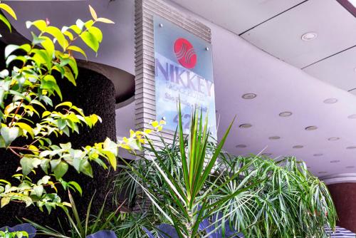 a group of plants in a room with a sign at Nikkey Palace Hotel in Sao Paulo