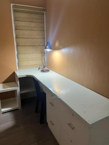 a white desk with a lamp in a room at Feel at home 2 bedroom apartment in Malolos