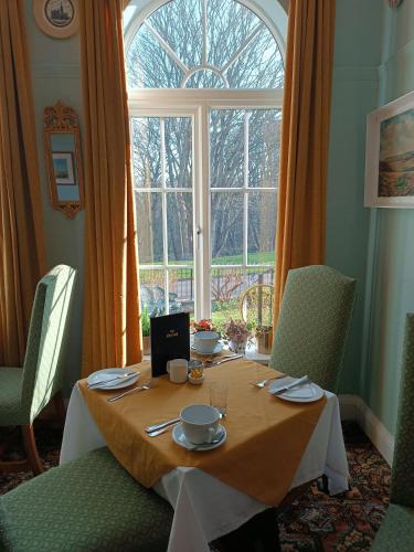 a table with plates and cups on it in front of a window at The Outlook Scarborough in Scarborough