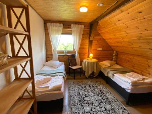 une chambre avec deux lits dans une cabane en rondins dans l'établissement Shanti Resort - Retreat & Wellness Center, à Sarboriškės I