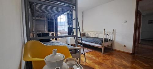 a room with bunk beds and a table with a yellow chair at Złoty Trakt pokoje i rowery in Złoty Stok