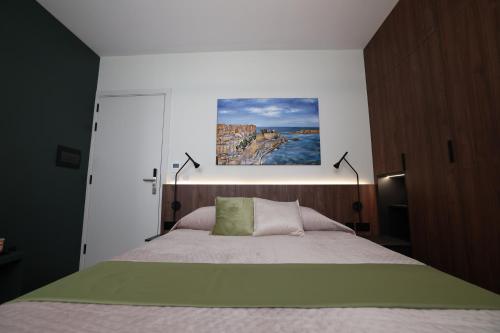 a bedroom with a bed with a painting on the wall at Bonaci Boutique Hotel in Sliema