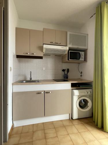 une cuisine avec un évier et une machine à laver dans l'établissement Studio dans le village des pecheurs de Carro, à Martigues
