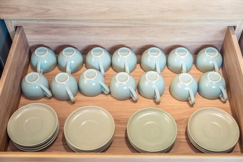 a wooden drawer filled with white bowls and plates at Merbrisa Rayong poolvilla 4BR - Ao khai beachfront in Mae Pim
