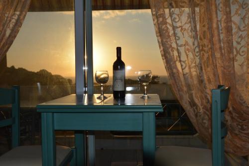 a bottle of wine and two glasses on a table with a window at Panorama in Skafidia