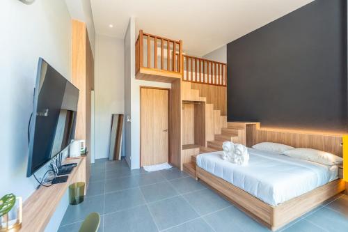 a bedroom with a bed and a tv and a staircase at Merbrisa Rayong poolvilla 4BR - Ao khai beachfront in Mae Pim