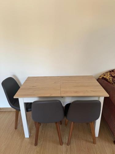 une table en bois entourée de deux chaises noires dans l'établissement T2 Rénové St-Priest centre avec Parking Privé, à Saint-Priest